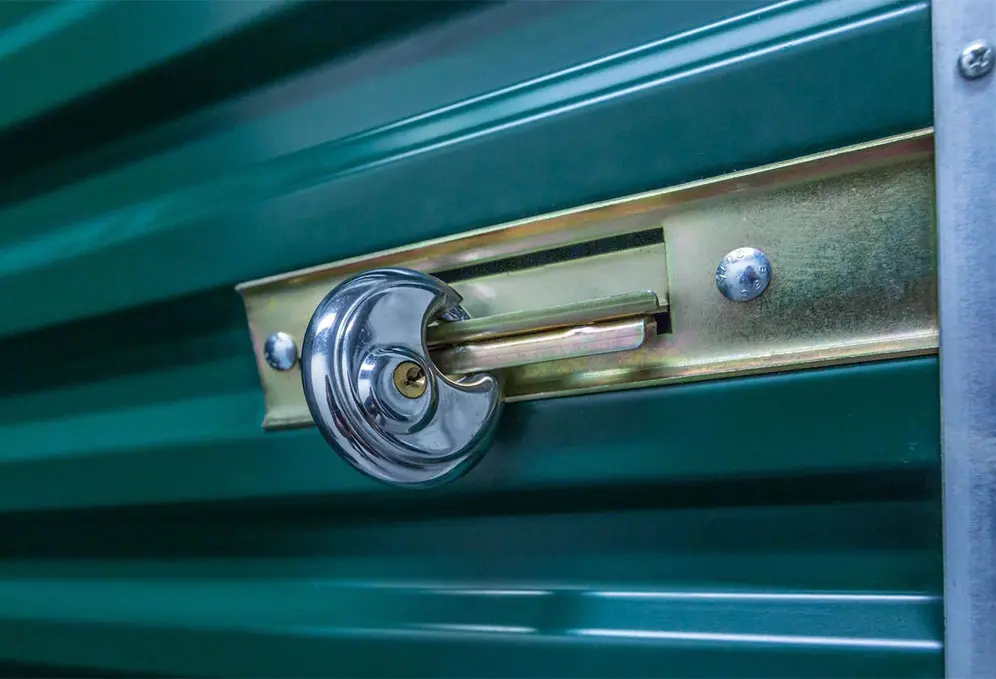 A close up of the lock on a green door.